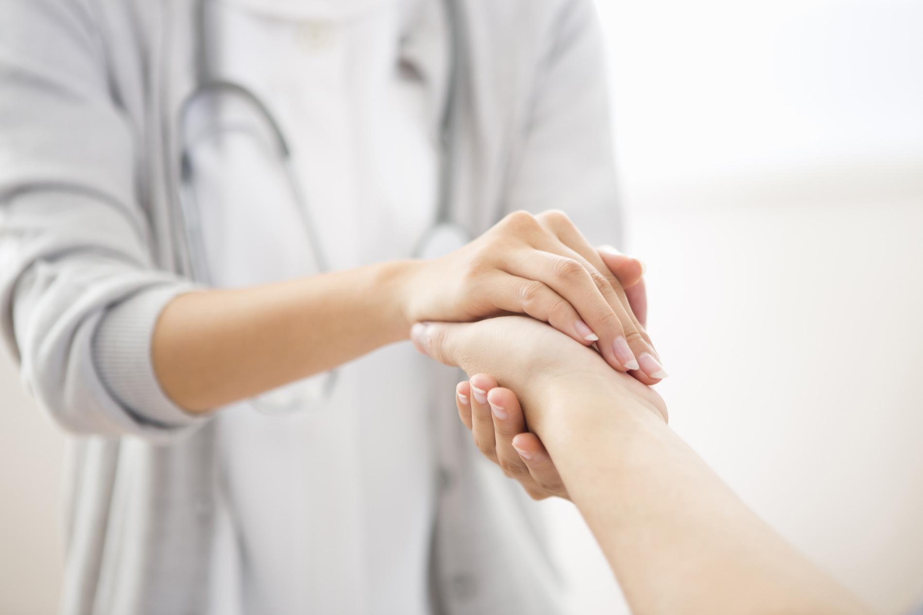 private duty nurse holding patient hand